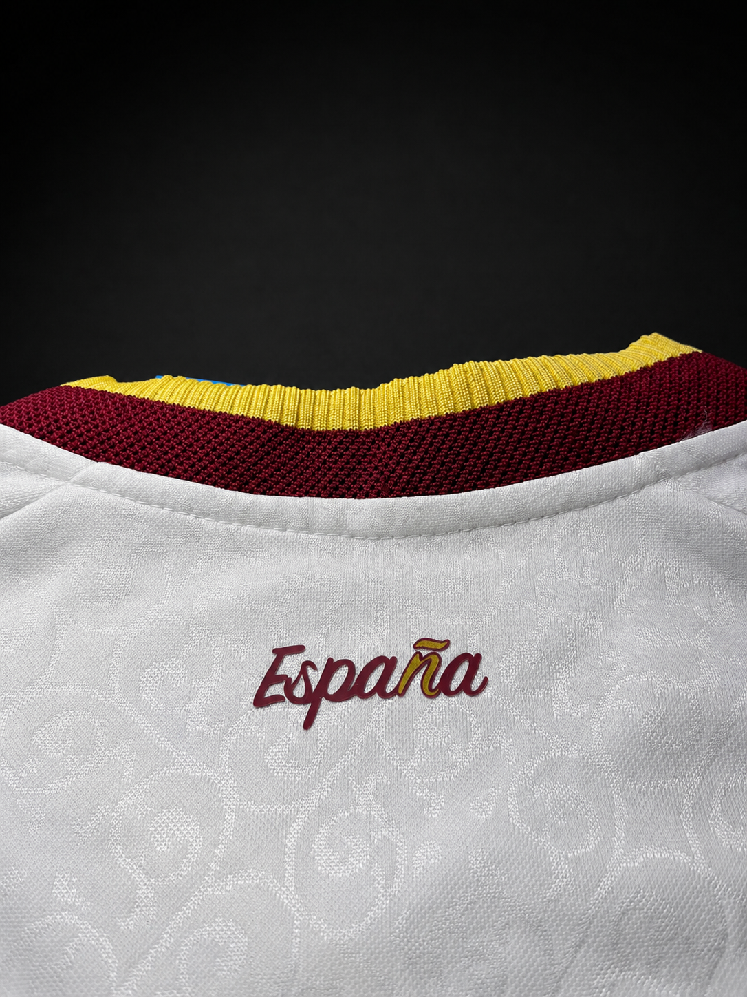 Cuello con la inscripción España de la camiseta blanca